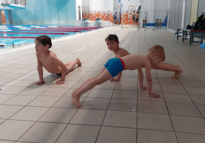 Dzieci ćwiczą przed wejściem do basenu.